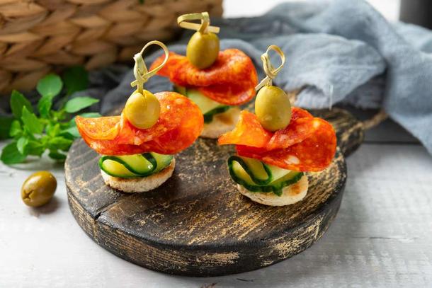 Канапе с острой колбаской пеперони и оливкой